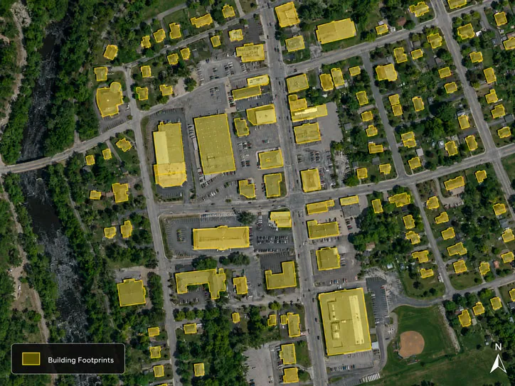Aerial image of a town with detected building footprints outlined in yellow